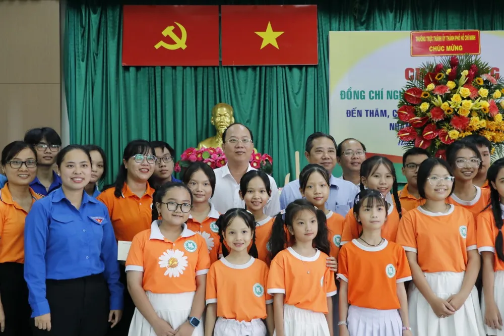 Đồng chí Nguyễn Hồ Hải cùng các đại biểu chụp hình lưu niệm với thiếu nhi huyện Hóc Môn. Ảnh: NGÔ BÌNH
