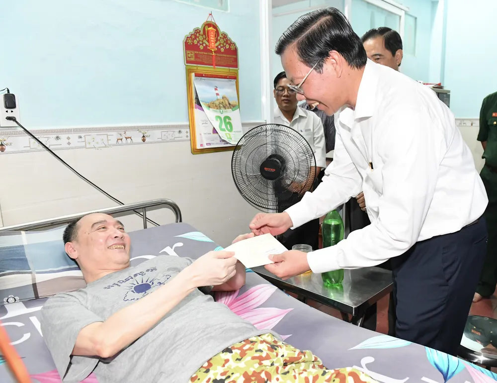 Đồng chí Phan Văn Mãi tặng quà thương binh Huỳnh Lập Hiến. Ảnh: VIỆT DŨNG