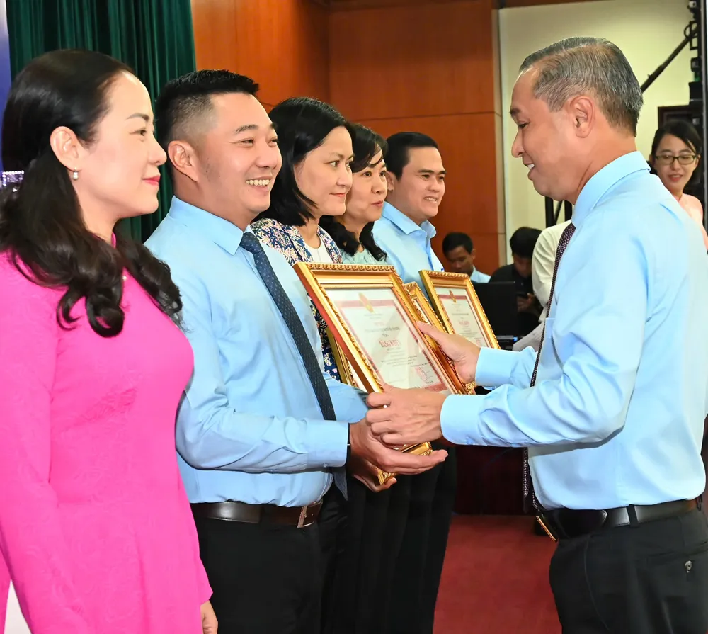Đồng chí Huỳnh Thanh Nhân trao Bằng khen của Chủ tịch UBND TPHCM đến cá nhân. Ảnh: VIỆT DŨNG 75d918a7a7b410ea49a5.jpg