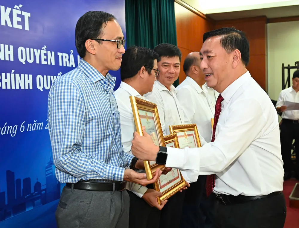 Đồng chí Phạm Thành Kiên trao Bằng khen của Chủ tịch UBND TPHCM đến các tập thể, cá nhân. Ảnh: VIỆT DŨNG a10fec175504e25abb15.jpg