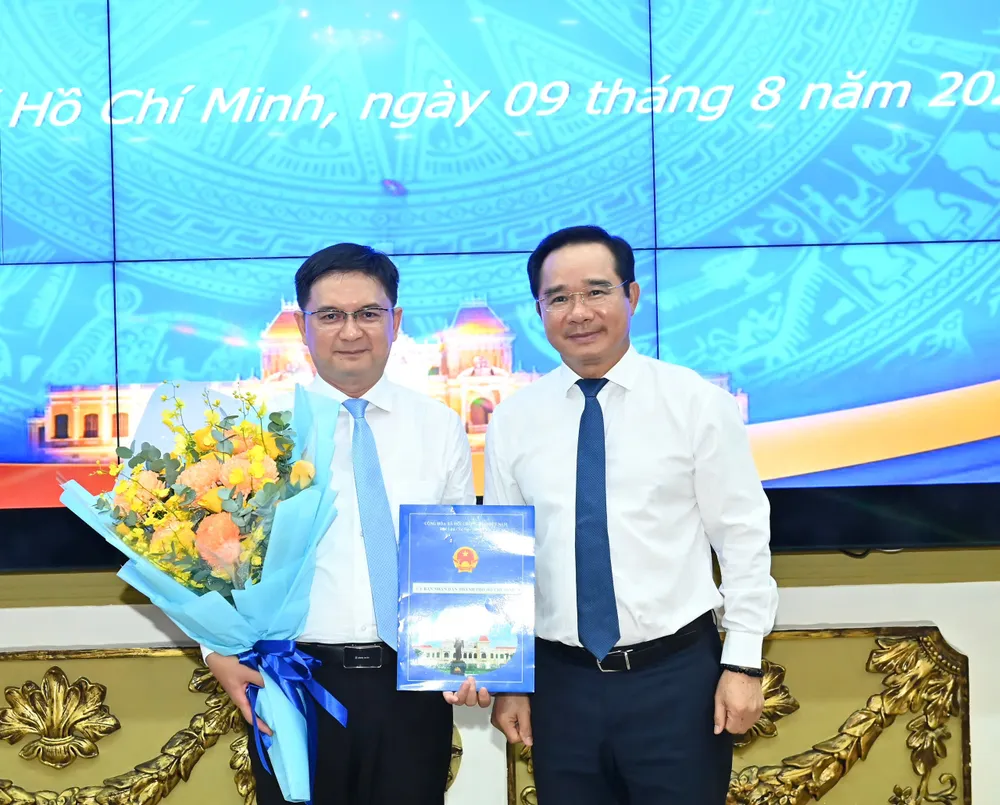 Chủ tịch UBND TPHCM Nguyễn Văn Được trao quyết định, tặng hoa chúc mừng đồng chí Nguyễn Mạnh Cường. Ảnh: VIỆT DŨNG z6888524213221_b8e9cf2d7fffdb53555c04b2c189ba7e.jpg