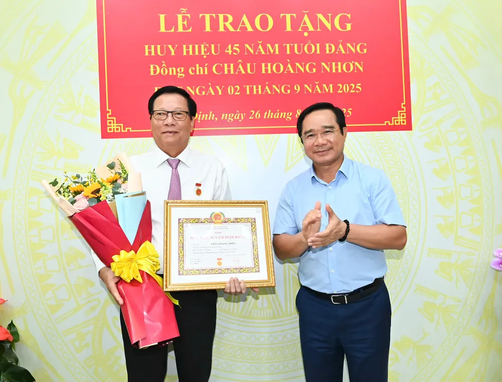 Đồng chí Nguyễn Văn Được trao Huy hiệu Đảng và hoa chúc mừng đồng chí Châu Hoàng Nhơn. Ảnh: VIỆT DŨNG z6946248628860_352bb74a0a56c9ec770e9a9ec2bcaea7.jpg