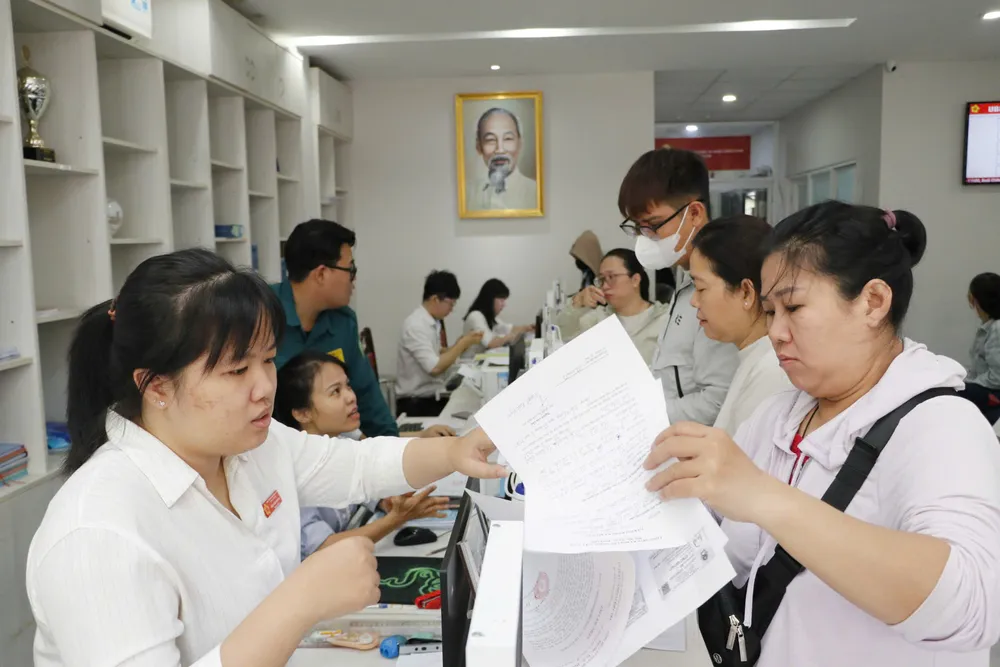 Công chức Trung tâm Phục vụ hành chính công phường Bến Thành (TPHCM) giải quyết hồ sơ cho người dân z6959271920266_c205fe0e7f6e19b9412ef2bf009348cb.jpg