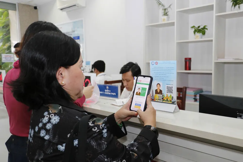 ប្រជាពលរដ្ឋស្កែន QR Code ដើម្បីវាយតម្លៃមន្ត្រីរាជការនៅហាងតែមួយនៃមជ្ឈមណ្ឌលសេវារដ្ឋបាលសាធារណៈ Ben Thanh Ward។ z7147457777891_3599d7f079a058dfeaab2b3a2b120e55.jpg