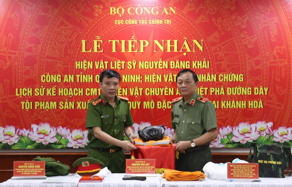 Đại diện Cục Cảnh sát điều tra tội phạm về ma túy trao tặng hiện vật sử dụng trong chuyên án triệt phá tổ chức tội phạm sản xuất trái phép ma túy tại Khánh Hòa. Ảnh: HOA NGUYỄN
