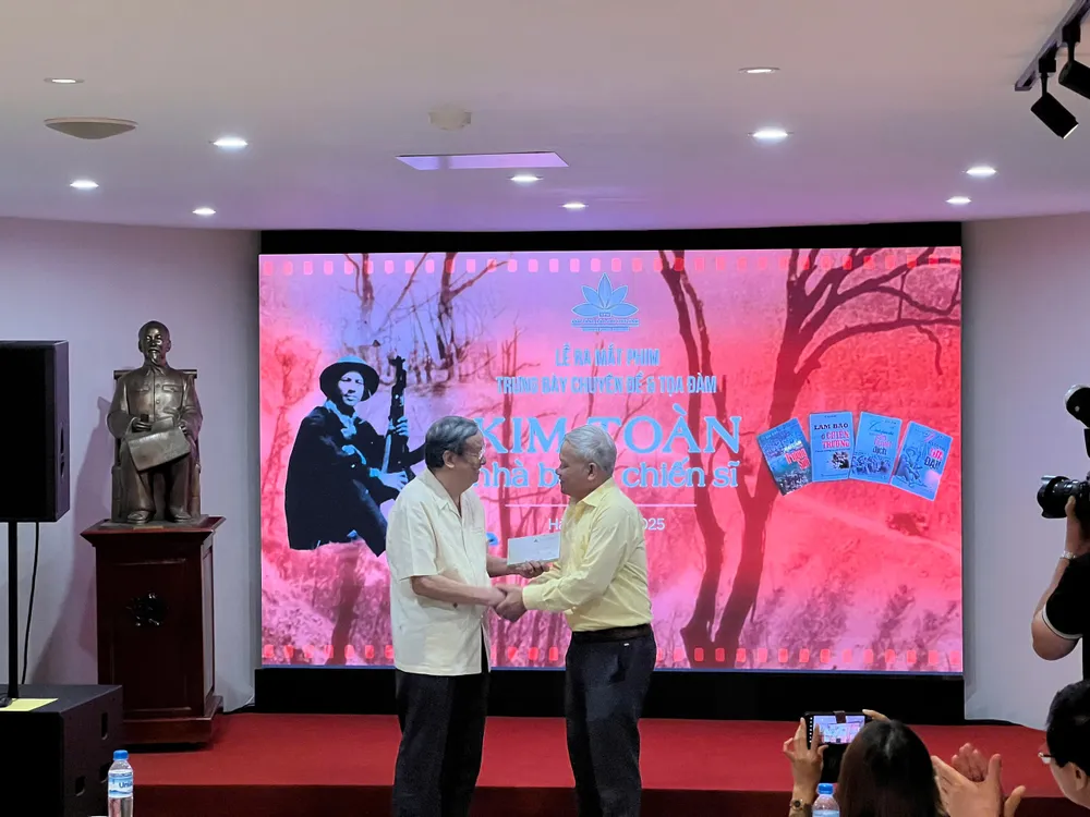 Nhà thơ Sĩ Đại, tác giả kịch bản trao bản phim gốc cho nhà báo Kim Toàn (trái) 9391184b13f2a7acfee3.jpg