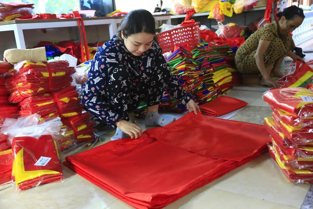 Gấp gọn lá cờ, đóng gói để chuẩn bị giao hàng cho khách. Ảnh: HÀ NGUYỄN 1bc879a9-1849-4e7a-b5ae-fb84b00802a2.jpg