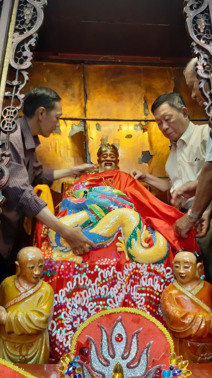 二府會館副理事長謝忠成（右）和諸位代表為神像更換袍冠。