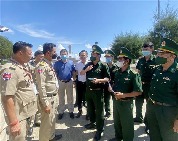 靖邊國際口岸邊防哨所幹部與柬埔寨職能力量就接收26名越南公民的手續進行交談。