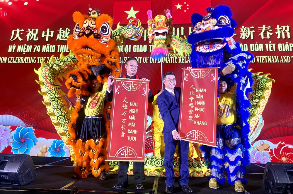 市人委会副主席阮文勇(右)与中国总领事魏华祥祝贺越中友谊万古长青。