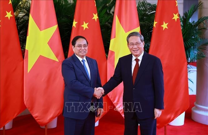越南政府总理范明政和中国国务院总理李强。图自越通社