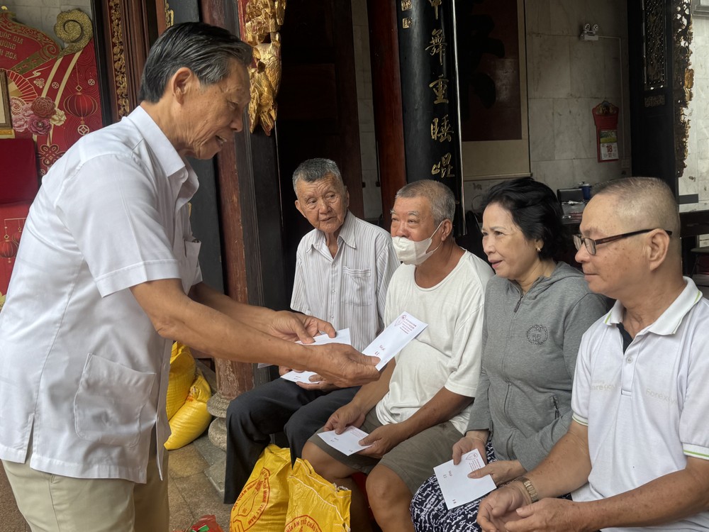 本市潮州义安会馆会长陈振炎向贫困乡亲赠送礼物。