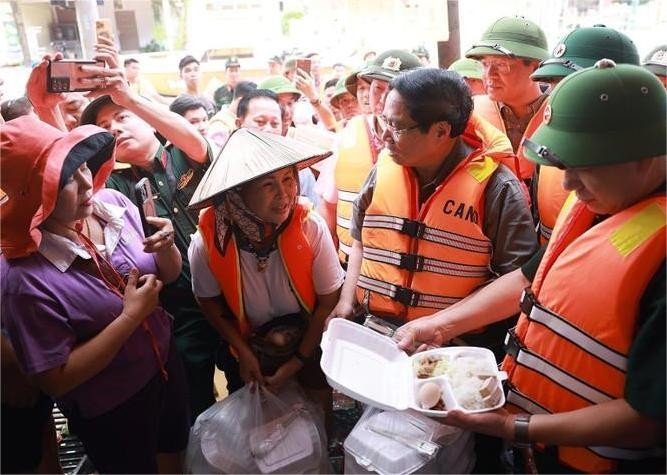 范明政总理慰问受洪灾影响民众。图自越通社 