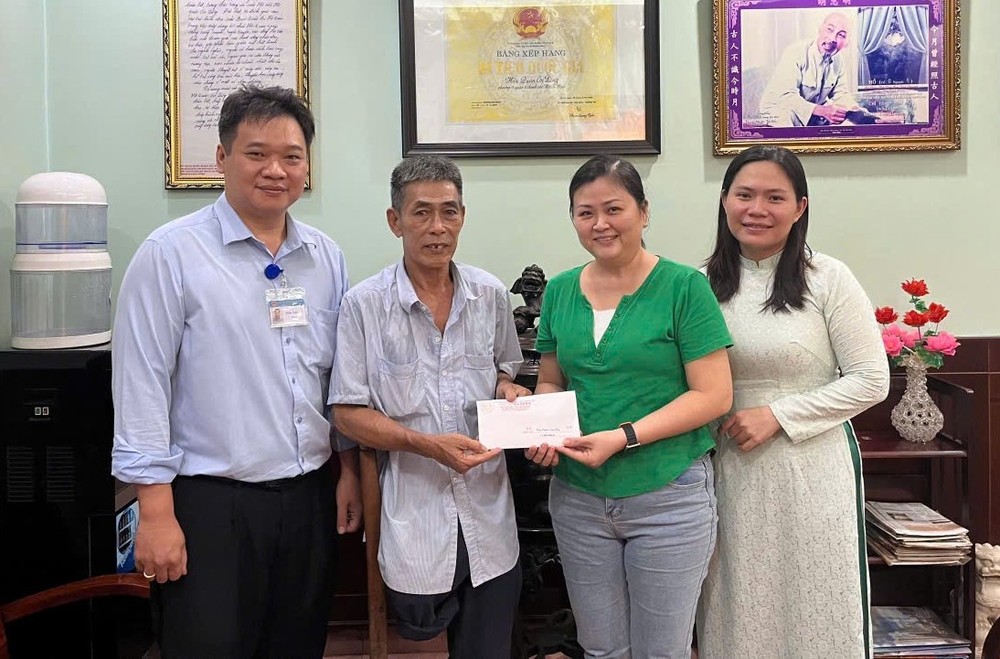 温陵会馆常值副会长吳丽株（右二）把半年生活额交给荣军阮文秋。