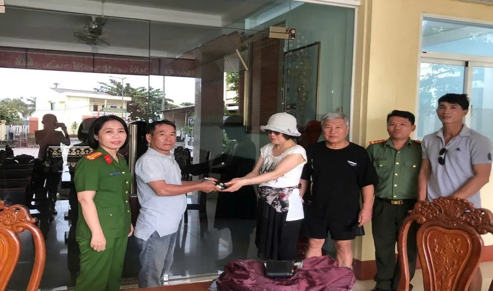 Vợ chồng du khách người Hàn Quốc (thứ 3, 4 từ trái qua) nhận lại tài sản đã đánh rơi 2.jpg