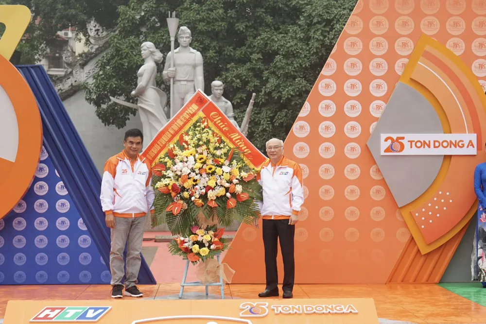 Ông Phan Nguyễn Như Khuê (phải) - Trưởng Ban Tuyên giáo Thành uỷ TPHCM tặng hoa chúc mừng cuộc đua. Ảnh: H.H