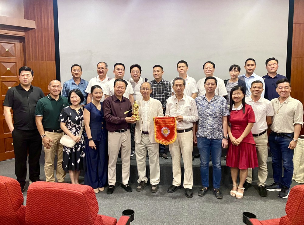 义安会馆理事长陈振炎、常值副理事长庄事勇向李玉明董事长赠送礼物，并与代表团合照。