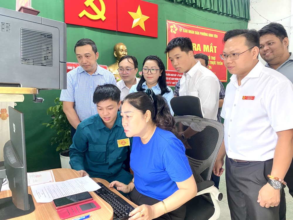 协助员正为居民办理线上输入手续。