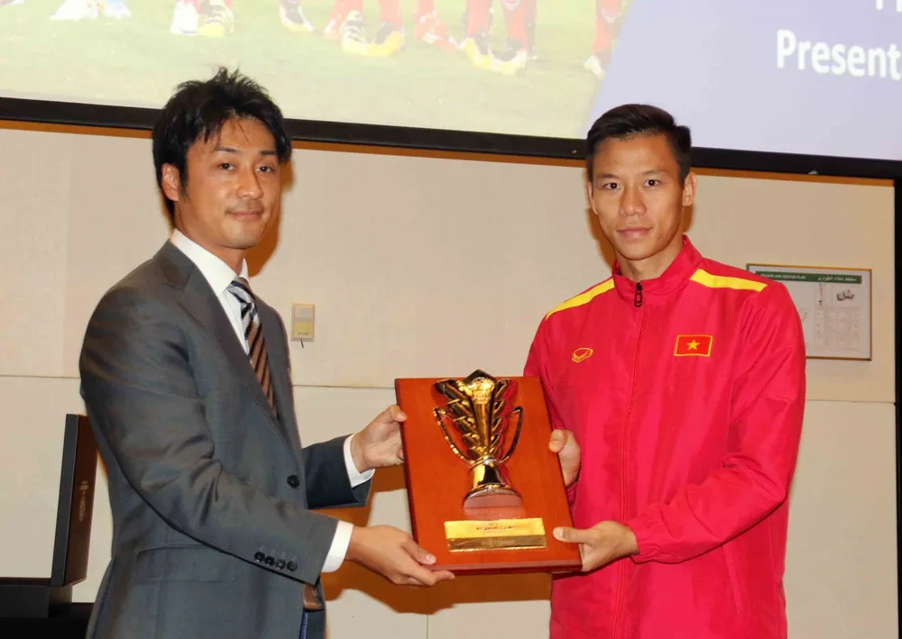 Thủ quân Quế Ngọc Hải đại diện toàn đội nhận kỷ niệm chương từ AFC. Ảnh: A.K