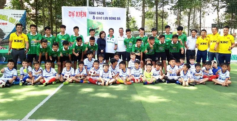 Các cầu thủ Học viện NutiFood chụp ảnh lưu niệm cùng các em ở Trung tâm Kidball. Ảnh: ANH TRẦN