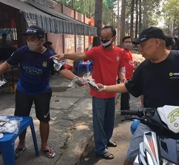 Hội CĐV CLB TPHCM phát khẩu trang cho người đi đường trên đường Đào Duy Từ. Ảnh: Anh Trần