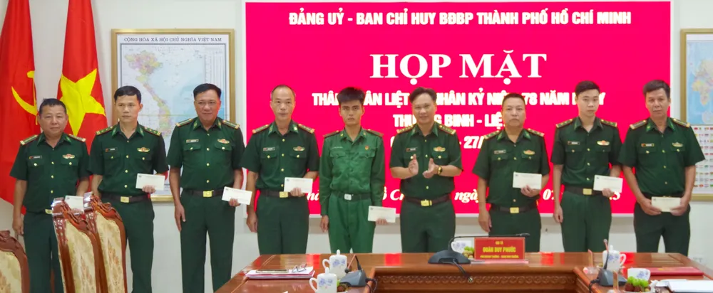 Đại tá Đoàn Duy Phước (thứ 4 từ phải vào) tặng quà các đồng chí là thân nhân liệt sĩ. ẢNH QUANG HUY 10.JPG