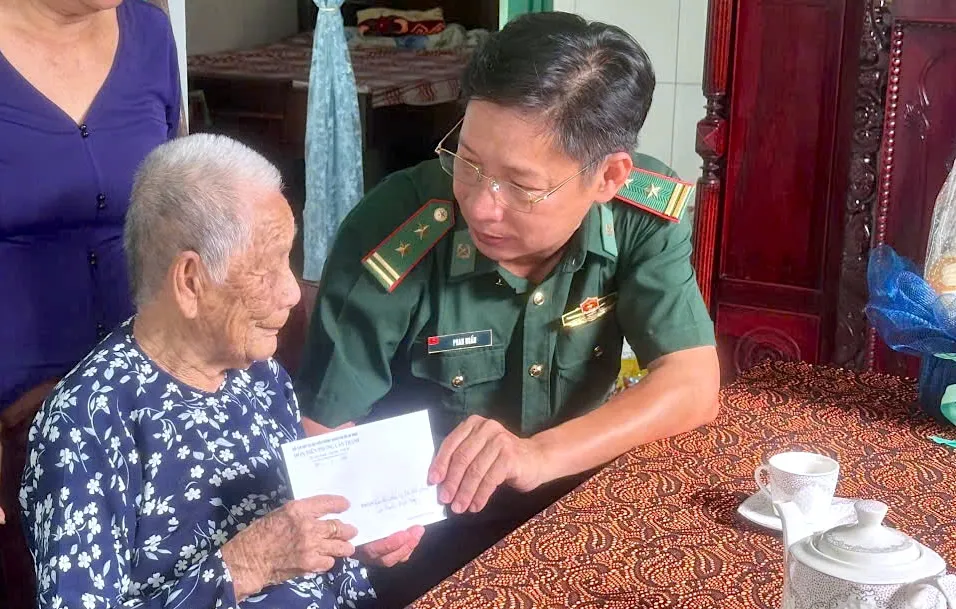 Trung tá Phan Huấn, Chính trị viên đồn Biên phòng Cần Thạnh tặng quà, tri ân Mẹ VNAH Nguyễn Thị Hay (104 tuổi). ẢNH QUANG HUY 9.jpg