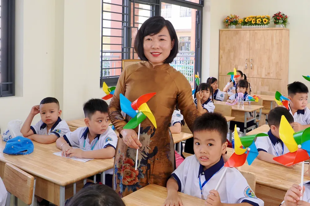 Cô Ngô Thị Thúy Lan, Hiệu trưởng nhà trường, chia vui cùng các học sinh lớp 1/1. Ảnh: HOÀNG HÙNG 2.jpg