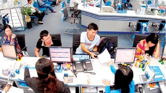 Customers do transactions at a bank. (Photo: SGGP)