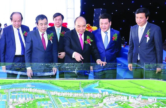 Prime Minister Nguyen Xuan Phuc and delegates watch the scale model of Lien Ha Thai Industrial Park - Thai Binh Economic Zone. (Photo: VNA)