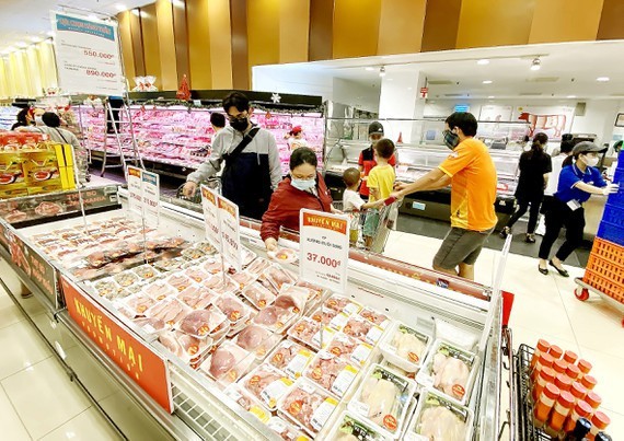 Consumers buy pork at a supermarket. (Photo: SGGP)