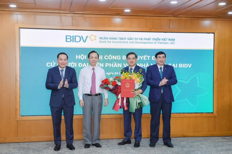 Phó Thống đốc thường trực NHNN Đào Minh Tú, Phó Bí thư Đảng ủy khối DNTW Hồ Xuân Trường trao Quyết định và chúc mừng ông Đặng Văn Tuyên. Ảnh: SBV.