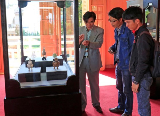 Visitors contemplate artifacts at the exhibition