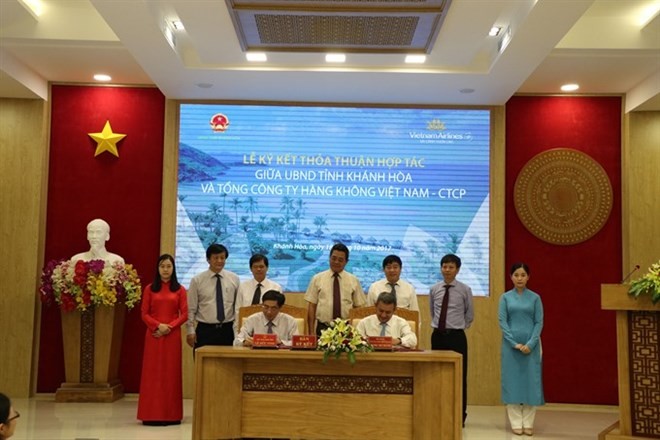 Chairman of Khanh Hoa province’s People’s Committee Le Duc Vinh (L) and General Director of Vietnam Airlines Duong Tri Thanh sign a deal on tourism development. (Photo: VNA)