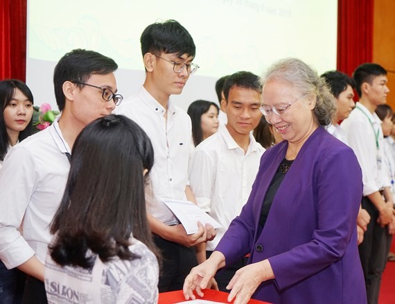 Chairperson of the Nguyen Van Huong scholarship fund council Dr. Truong Thi Xuan Lieu presents scholarships to students. (Photo: Sggp)