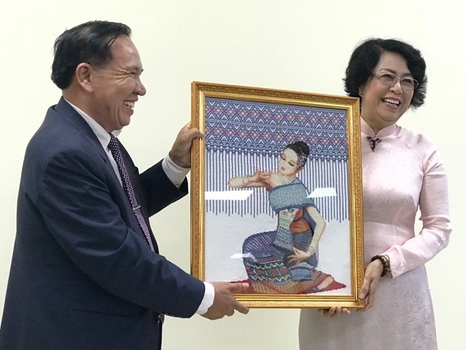 Chairman of the Lao Front for National Construction – Vientiane chapter Bounthieng Khounsy (L) presents a picture to To Thi Bich Chau, Vice President of the Vietnam Fatherland Front – Ho Chi Minh City chapter (Source: daidoanket.vn)