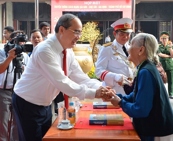 Secretary of the HCMC Party Committee Nguyen Thien Nhan talks with a delegate in the meeting. (Photo: sggp)