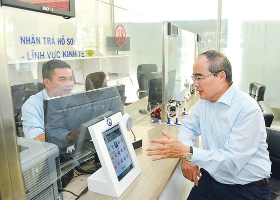 Secretary of HCMC Party Committee Nguyen Thien Nhan talks with an official of the People’s Committee of District 12.