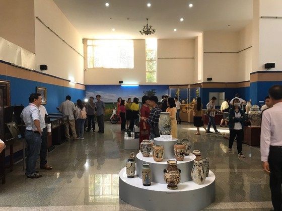 Visitors contemplate antiques in the exhibition. (Photo: SGGP)