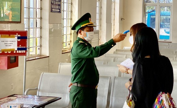 Sa Ky seaport’s staff is measuring the temperature of visitors before travelling to Ly Son island. (Photo: SGGP)