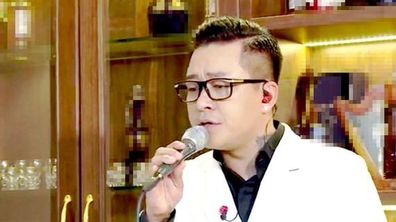Singer Tuan Hung sings at his online performance.