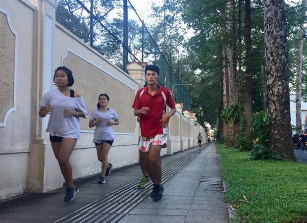 People exercise on pavement near the Independence Palace in HCM City’s District 1. (Photo: VNA)