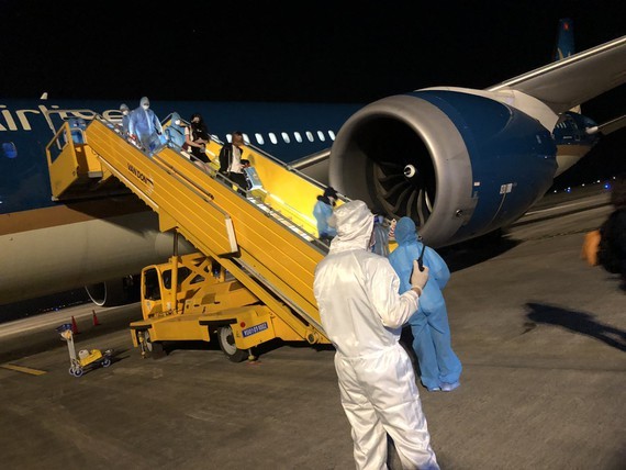 Vietnamese people return home on a repatriation flight in Van Don Airport. (Photo: SGGP)