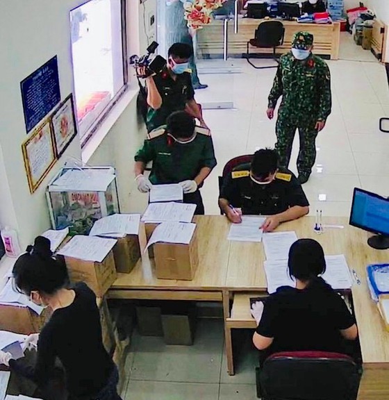 Representatives of the HCMC High Command complete procedures to receive ashes of Covid-19 victims at the Binh Hung Hoa Cremation Center in Binh Tan District. (Photo: SGGP)