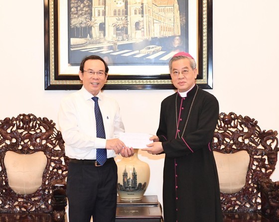 Secretary of the HCMC Party Committee Nguyen Van Nen (L) offers gifts to the Archbishop of the Archdiocese of HCMC, Nguyen Nang on the occasion of the Christmas season. (Photo: SGGP)