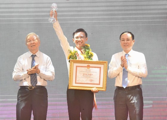 Vice Secretary of the HCMC Party Committee, Nguyen Van Hieu (R) offers a certificate of merit to Vu Minh Vuong (C), a technology teacher cum secretary of the Youth Union of teaching staff of the Le Van Tam Secondary School in Binh Thanh District. (Photo: SGGP) Vice Secretary of the HCMC Party Committee, Nguyen Van Hieu (R) offers a certificate of merit to Vu Minh Vuong (C), a technology teacher cum secretary of the Youth Union of teaching staff of the Le Van Tam Secondary School in Binh Thanh District. (Photo: SGGP)