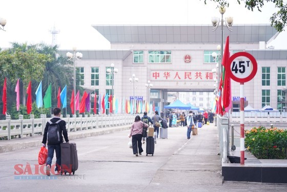 The first Chinese citizens cross the border following the reopening of crossing points Sunday. (Photo: SGGP)