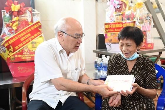Head of the Propaganda and Education Board of the City Party Committee Phan Nguyen Nhu Khue (L) offers present to Mrs. Luong Ha Nu. (Photo: SGGP)