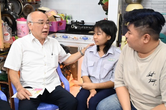 Head of the Propaganda and Education Board of the City Party Committee Phan Nguyen Nhu Khue (L) talks with brothers Tran Gia Yen orphaned from the Covid-19 pandemic. (Photo: SGGP)
