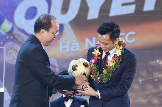 Vice Secretary of the HCMC Party Committee Nguyen Ho Hai presents the Golden Ball award to striker Nguyen Van Quyet (R). (Photo: SGGP)